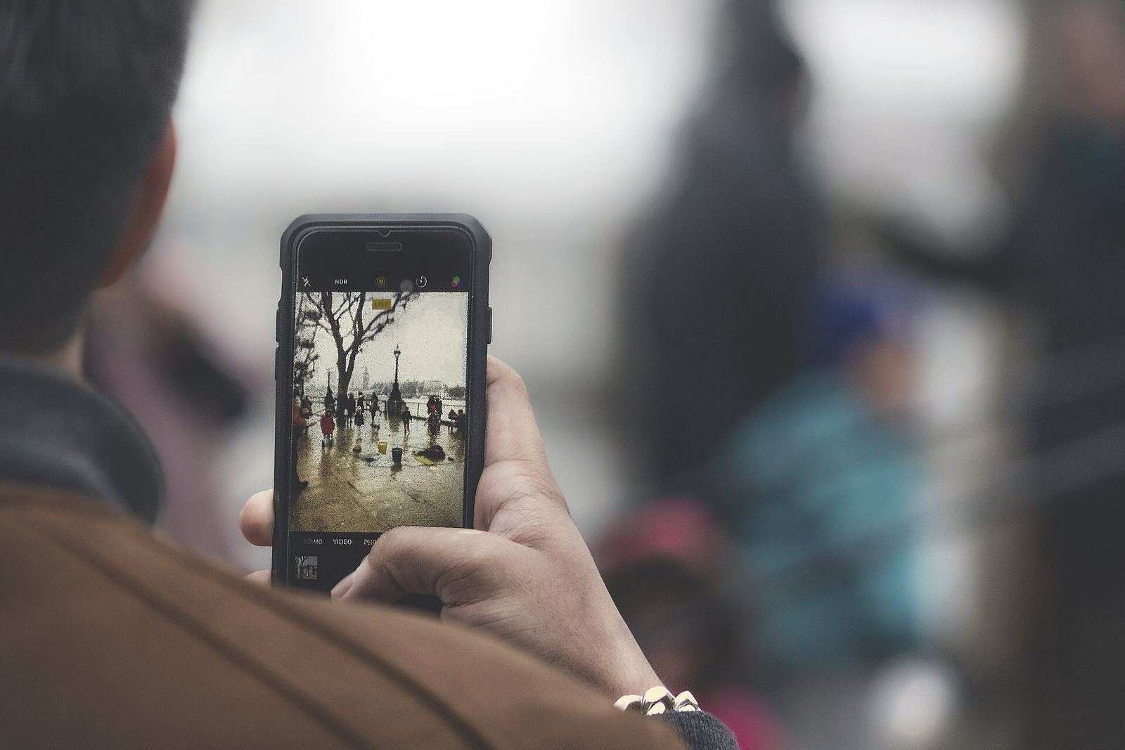 Person filming a street scene with a smartphone